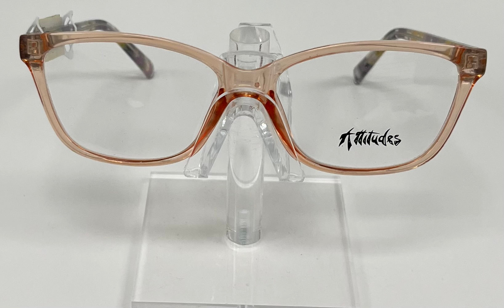 A pair of peach-colored eyeglasses with bold purple and yellow temples, displayed on a stand.