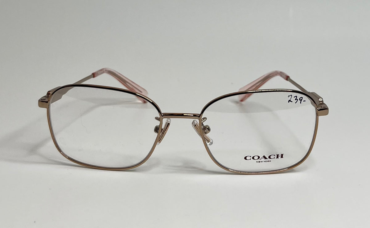 Coach eyeglasses with a metallic rose gold frame and clear lenses, featuring the Coach logo on the lower right lens and a handwritten price of 23.99 on the upper right lens.