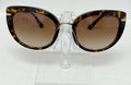 Tortoiseshell sunglasses on a clear stand against a white background