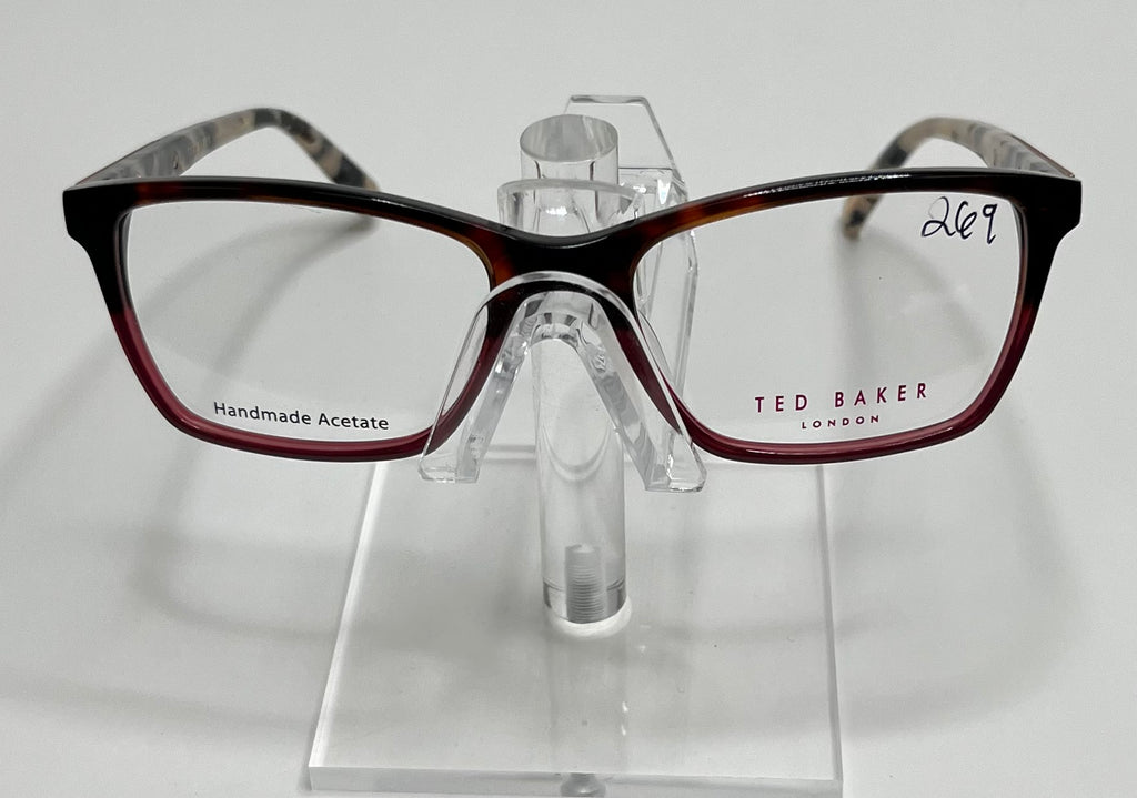 A pair of Ted Baker TPW006 ladies eyeglass frame in tortoise and blue color, displayed on a stand.