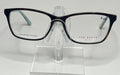A pair of Ted Baker B740 plastic eyeglass frames in blue and tortoise colors, displayed on a stand.