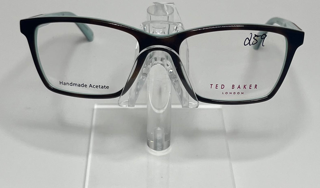 A pair of Ted Baker brand eyeglasses with a red and tortoise color scheme, displayed on a clear stand.
