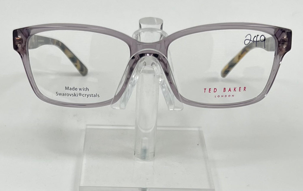 Gray eyeglasses on a stand with 'Ted Baker London' branding on a white background