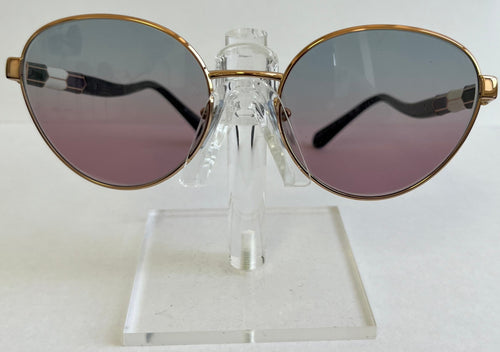 Sunglasses with gold frame and pink-tinted lenses on a clear stand against a white background